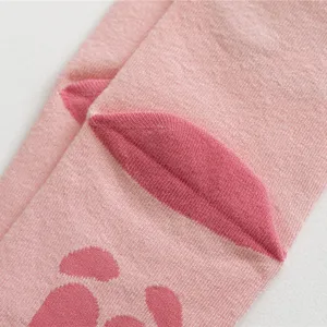 Close-up detail of cute pink animal paw knit socks, funny novelty winter crew socks style.