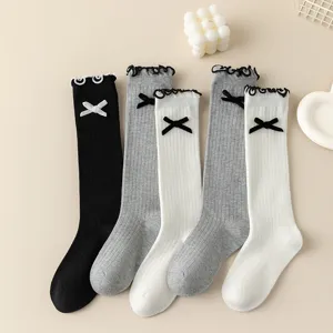Cute knee high knit socks with sweet bows and delicate ruffles for daily wear style.