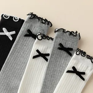 Close-up detail of Japanese style knit calf socks with sweet bow and lace ruffle trim.
