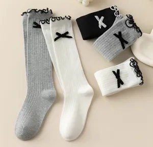 Details of Japanese style cute knit knee high socks with ruffles and bow decorations.