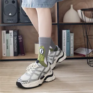 Close-up detail of cute cartoon frog pattern mid-tube socks paired with casual sneakers.