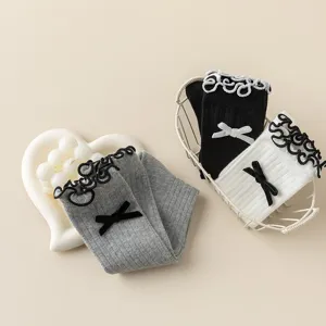 Close-up detail of Japanese sweet knit calf socks with delicate lace trim and black bow.