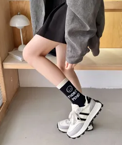 Lässige schwarz-weiße Mittelsocken mit Buchstabenstrick und süßem Smiley-Gesicht für Damen.