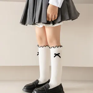 Japanese sweet style knit calf socks detail, featuring cute black bows and ruffled top trim.