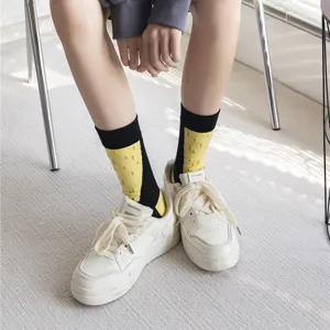 Detail shot of creative black and yellow color-blocked mid-calf socks worn with sneakers.