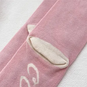 Close-up detail of pink novelty animal hoof knit socks with soft ribbed texture, cozy and cute.