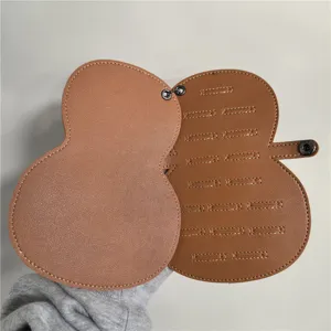 Étui médiator guitare en cuir marron avec 17 fentes de rangement et fermeture à bouton-pression.