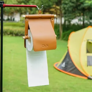 Hanging leather toilet paper holder with wooden stick for outdoor camping and bathroom use.