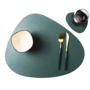 Detailed view of irregular green table placemat set with bowl and cutlery for dining.