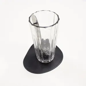 Detailaufnahme des schwarzen unregelmässigen Filzuntersetzers mit klarem Glas.