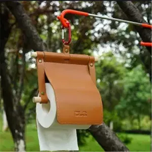 Outdoor camping leather toilet paper holder detail with wooden rod and hanging carabiner.