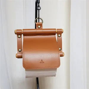 Hanging leather toilet paper holder detail shot, brown PU leather with wood stick design.