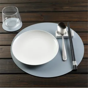 Detail view of round PU leather placemat table setting with matching coaster and tableware.