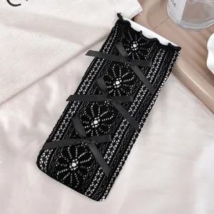 Calze alte in pizzo nero con fiocchi, dettaglio stile lolita dolce per ragazze.