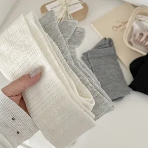 Detailansicht atmungsaktiver Mesh-Strick-Wadensocken in Weiß und Grau, weich und bequem.