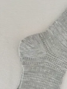 Detailaufnahme grauer atmungsaktiver Mesh-Strümpfe für den täglichen Sommergebrauch.