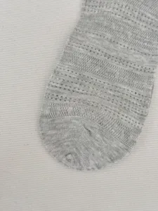 Nahaufnahme von grauen, atmungsaktiven Sommersocken mit Netzstrickmuster im Detail.