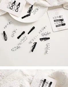 Vue détaillée de pinces à cheveux à pois noirs et blancs avec nœuds mignons sur des cartes.