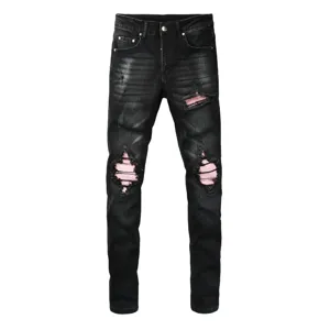 Black distressed ripped jeans for men with pink ribbed fabric patches streetwear fashion detail view
