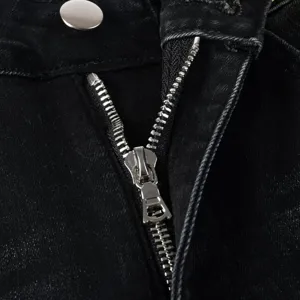 Close-up detail shot of the zipper and button on stylish black washed men's denim jeans.