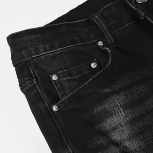 Close-up detail of black washed distressed men denim jeans with cool metal rivets.
