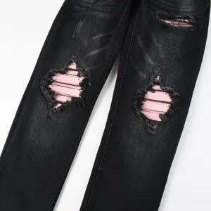 Black distressed denim jeans for men featuring stylish pink patch details on the knees.