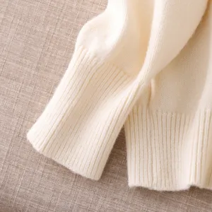 Close-up detail of off-white knitted sweater sleeve cuff, soft texture and cozy vintage style.