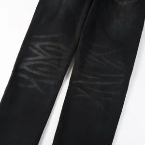 Close-up detail of black washed denim jeans featuring unique knee whiskered gothic patterns.