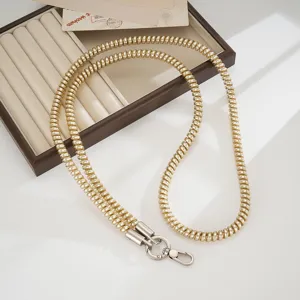 Gold coiled spring phone lanyard strap, crossbody metal chain detail for outdoor anti-loss use.
