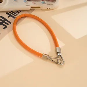 Orange PU leather wrist strap detail showing metal clasps, perfect for phone cases.