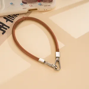 Brown PU leather short phone wrist strap with silver metal clasps, stylish accessory.