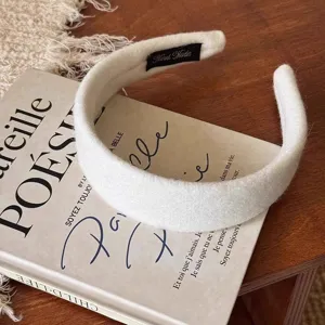 Nahaufnahme eines weißen Wollfilz-Breithaarreifens auf einer Vintage-Buch-Requisite.