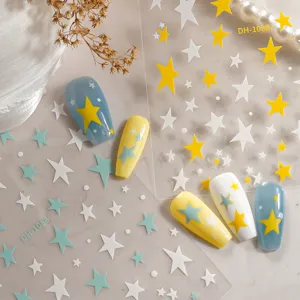 Nail sticker detail showing colorful star patterns and matching polished fake nails close up.