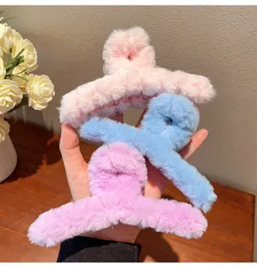 Detailed shot of fluffy plush hair claw clips in soft pastel colors, cute winter hair accessory.
