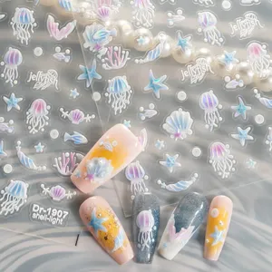 Détails en gros plan d'autocollants d'ongles méduse coquillage gaufrés 5D et faux ongles.