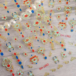 Detailed shot of 3D metallic gold Chinese style nail art stickers featuring floral patterns.