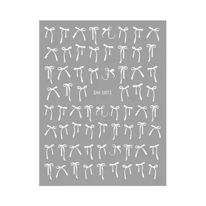 Close-up detail of white bow nail art stickers sheet, minimalist design for manicure decoration.