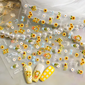 Close-up detail shot of 5D embossed sunflower nail art stickers with cute bows and grid patterns.
