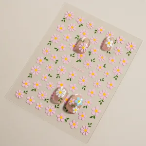 Close-up detail of 3D floral nail art stickers sheet with colorful daisy flower patterns.