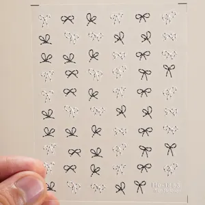 Detailed view of 5D embossed black and white polka dot bow nail art stickers sheet.