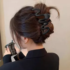 Elegant black wavy hair claw clip for women, stylish shark clip for secure and chic daily updos.