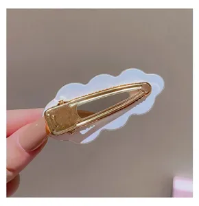 Korean style geometric cloud hair clip detail, transparent acrylic design with gold metal.