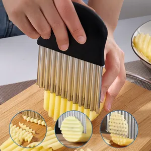 Close-up of stainless steel crinkle cutter slicing potato on wooden board cleanly.