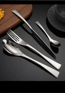 Dettaglio set di posate in acciaio inossidabile con coltello forchetta e cucchiaio nero.
