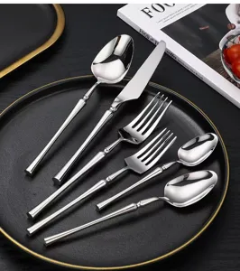 Détail de couverts en acier inoxydable, élégante fourchette et cuillère sur l'assiette.