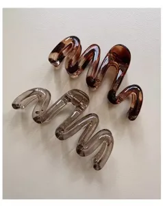 Detailed view of wavy hair claw clips in translucent smoke grey and tortoiseshell brown.