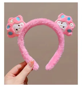 Detailopname van de roze pluche kattenpoot haarband, zachte stof en schattig ontwerp.
