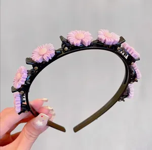 Close-up detail of a black plastic multi-clip hair hoop adorned with cute pink floral charms.
