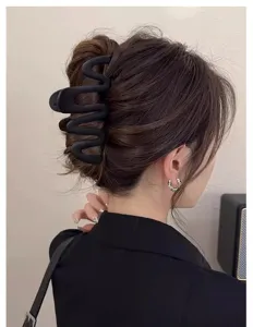 Detail shot of black matte wave hair claw clip showcasing unique niche design for elegant hairstyles.