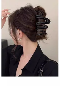 Detailed view of a stylish black wave hair claw clip showcasing its unique design and strong grip.
